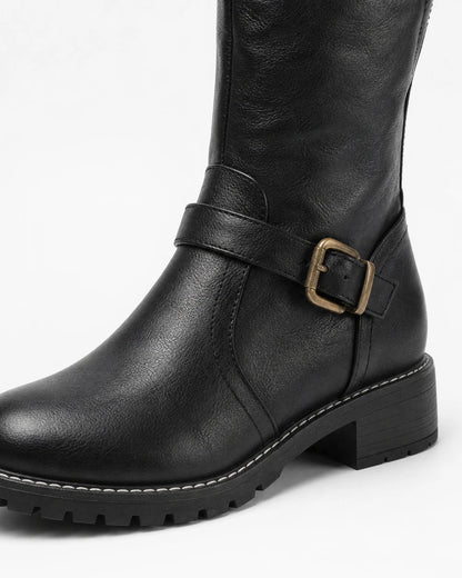 Women's black riding boot, buckle and lug-sole detail.