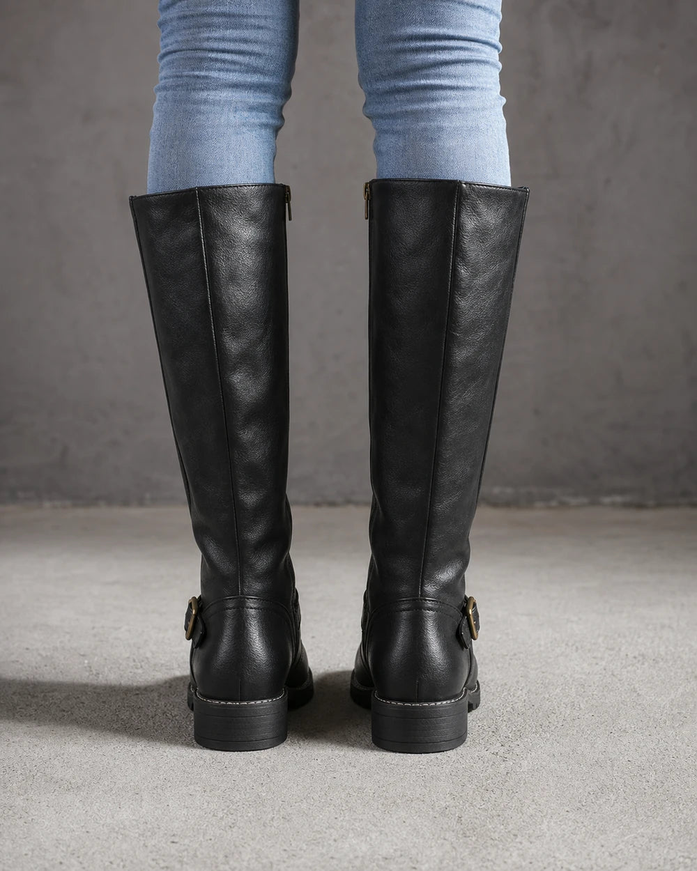 Women's black buckle-strap knee-high riding boots, rear view.