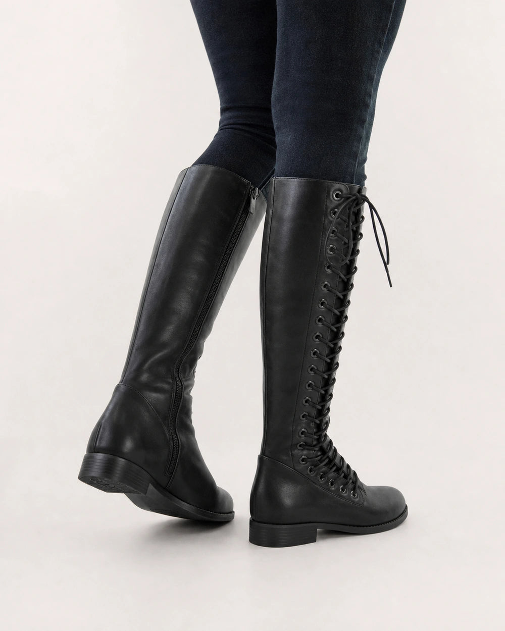 Women's black lace-up knee-high boots, rear three-quarter view.