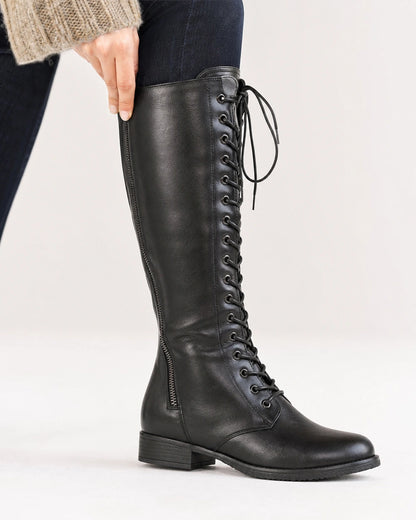 Black knee-high boot showing the full front lacing, eyelets, smooth finish and low heel.