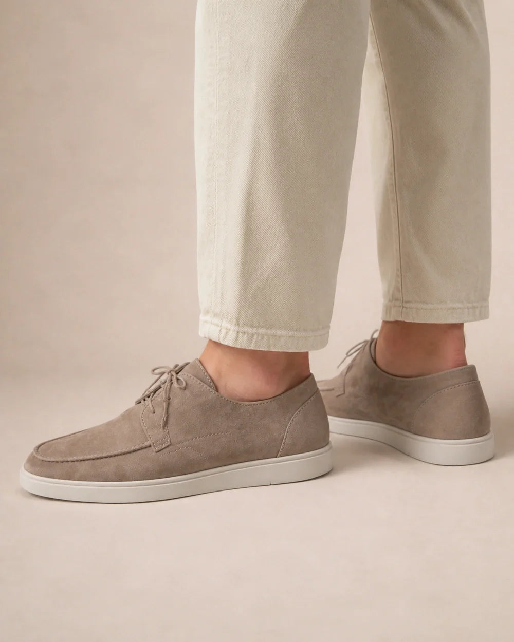 Rear three-quarter view of beige lace-up moccasins.
