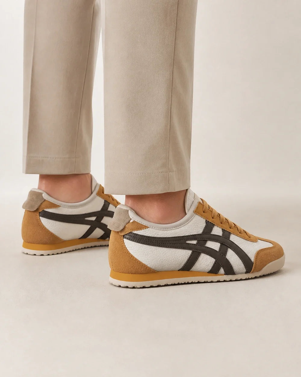 Rear three-quarter view of brown-yellow retro panel sneakers.