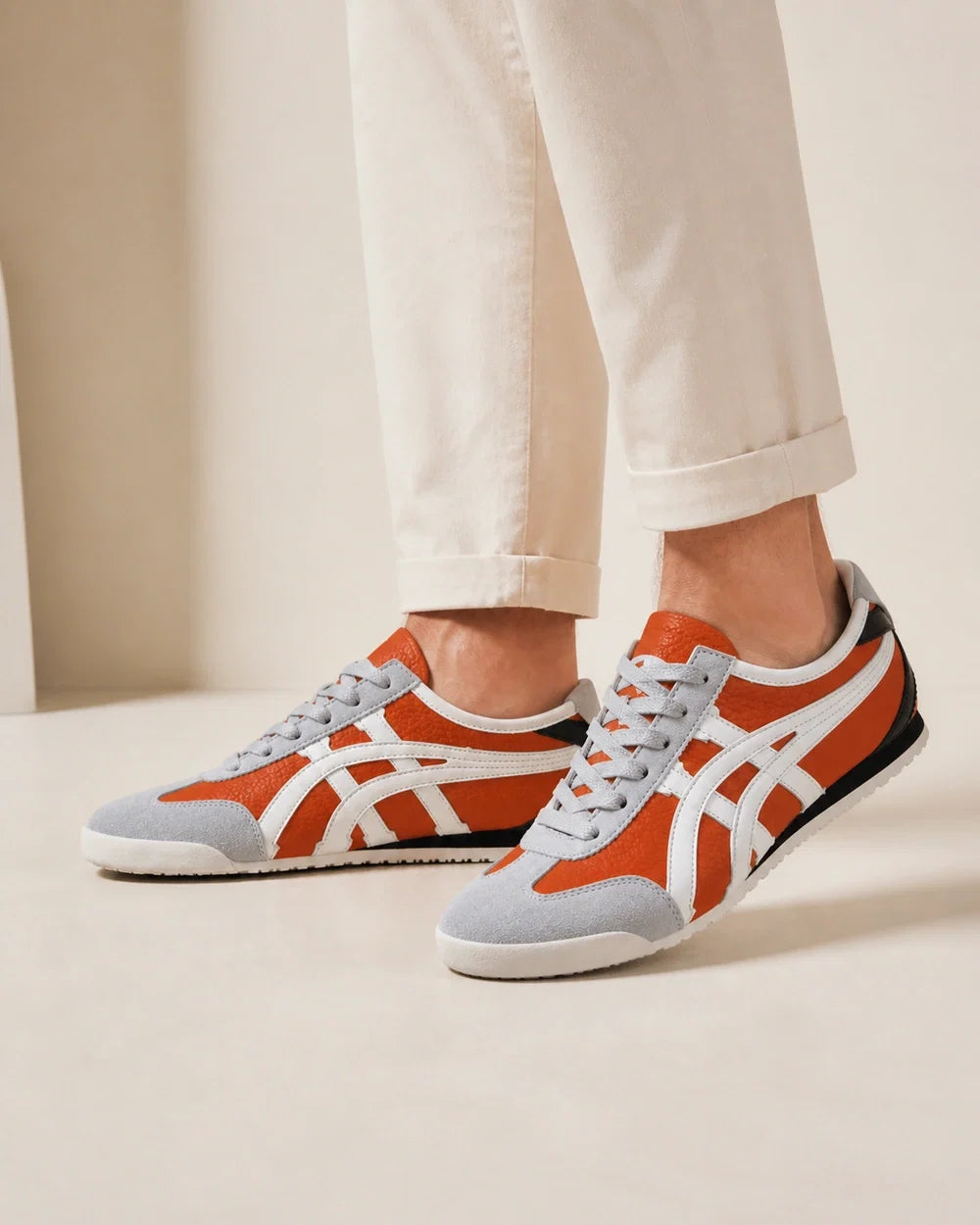 Men wearing grey-orange retro panel sneakers, close product-first view.