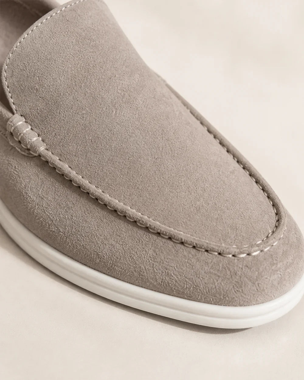 Close detail of beige loafer apron stitching and contrast sole.