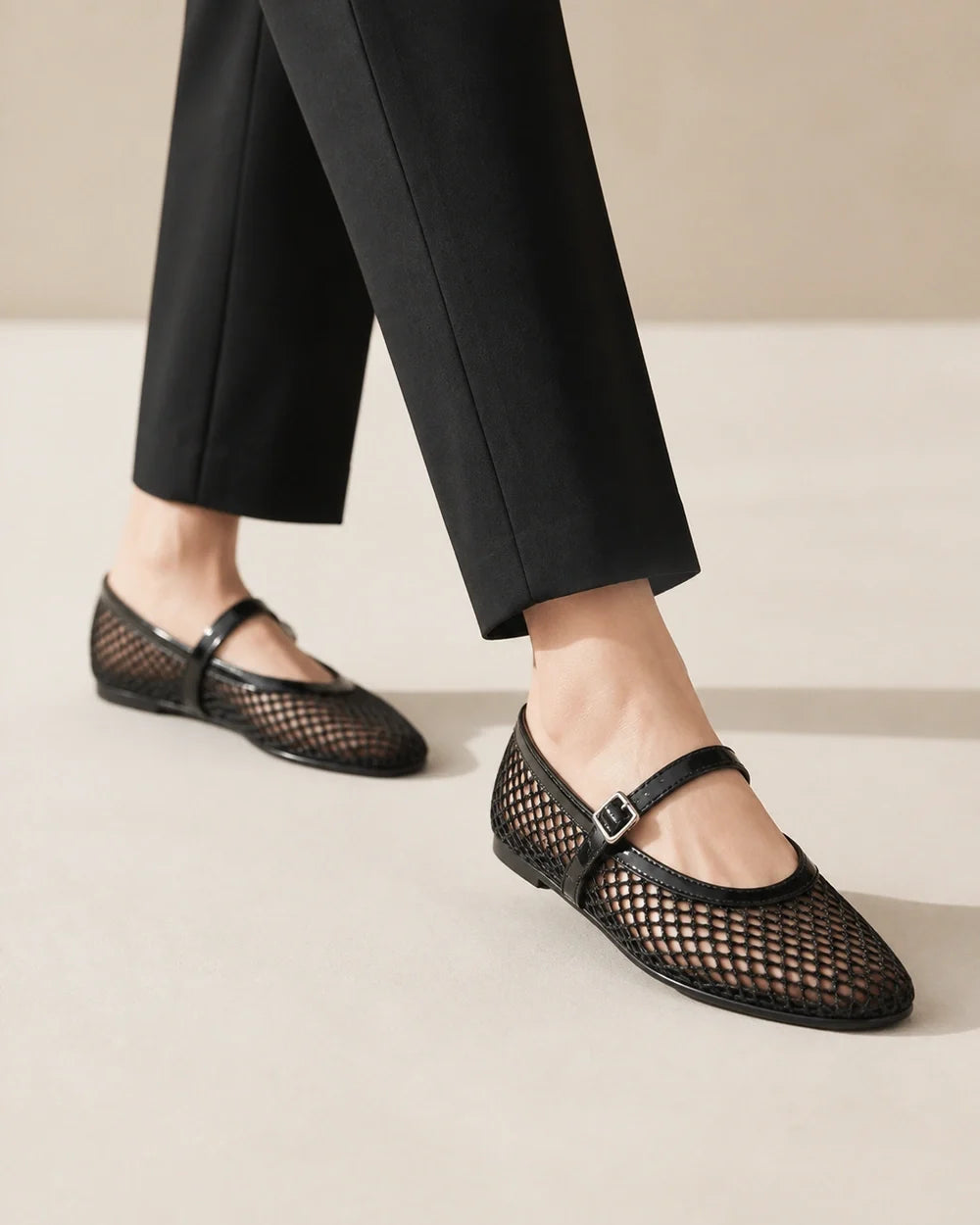 Women’s black mesh Mary Jane ballet flats, worn walking view.