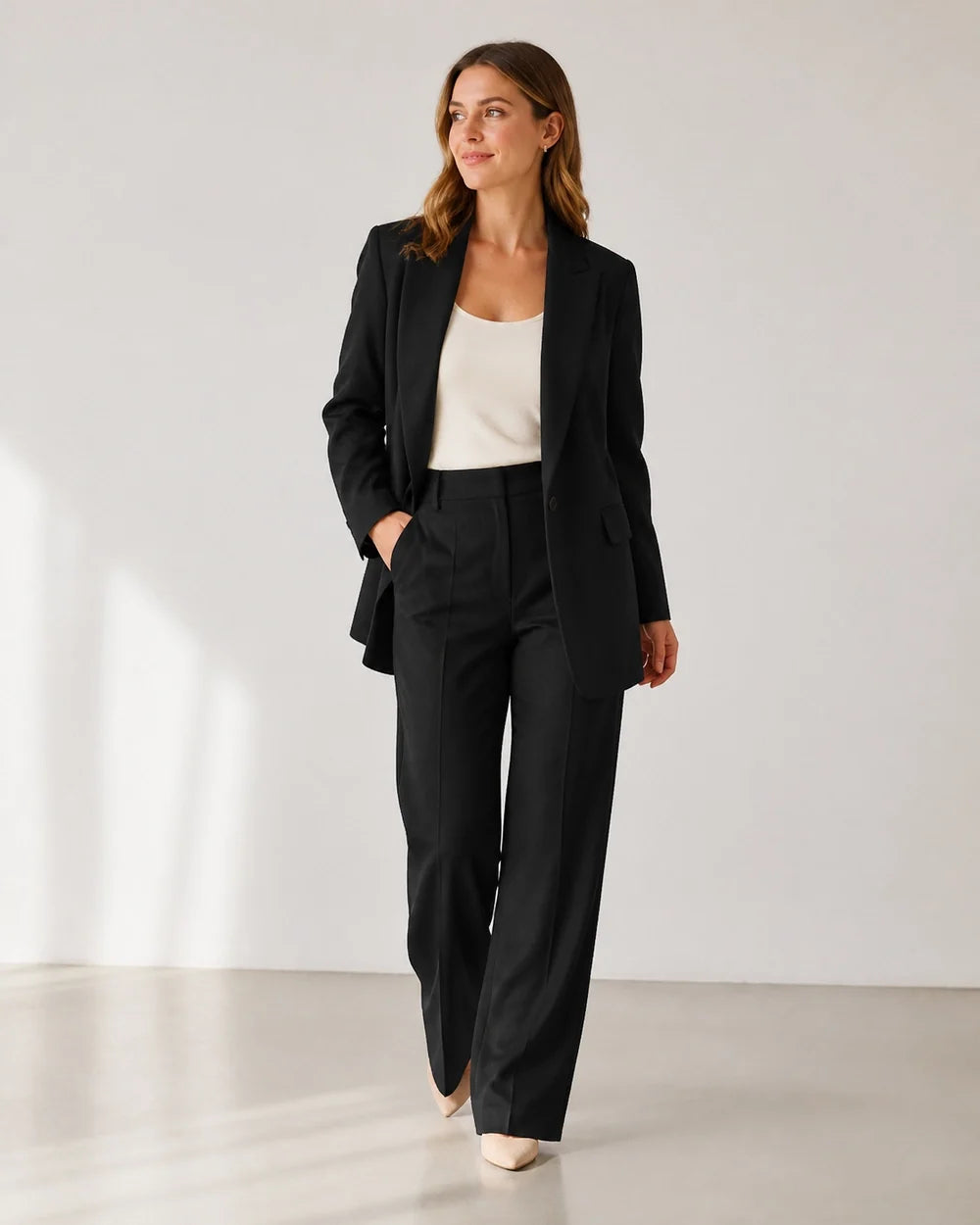 Black relaxed blazer and wide-leg trousers set for women, walking view
