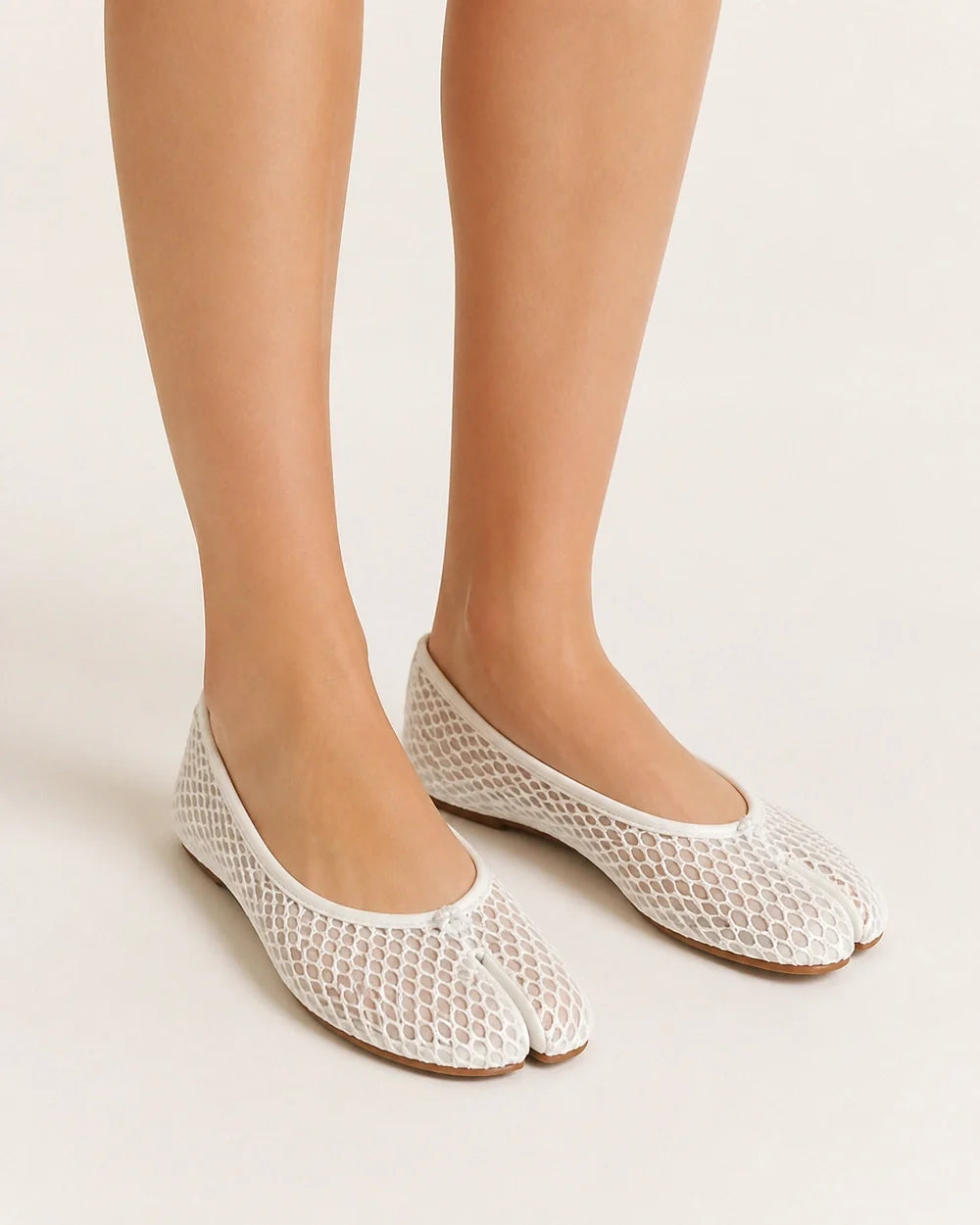 Women's white mesh tabi ballet flats, worn front three-quarter view.