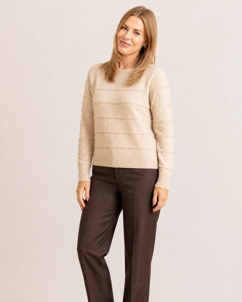 Women's oatmeal textured stripe sweater styled with brown trousers