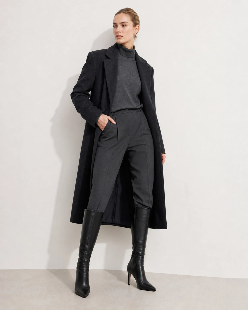 Women's black pointed-toe knee-high boots with a stiletto heel, full silhouette.